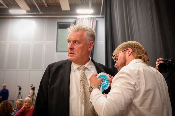 Reform UK candidate Lee Anderson pictured as a rosette is pinned to his jackets shortly after arriving at the Ashfield constituency count