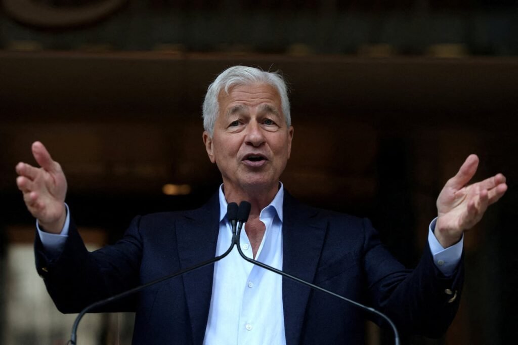 A man wearing a suit jacket gestures while speaking.