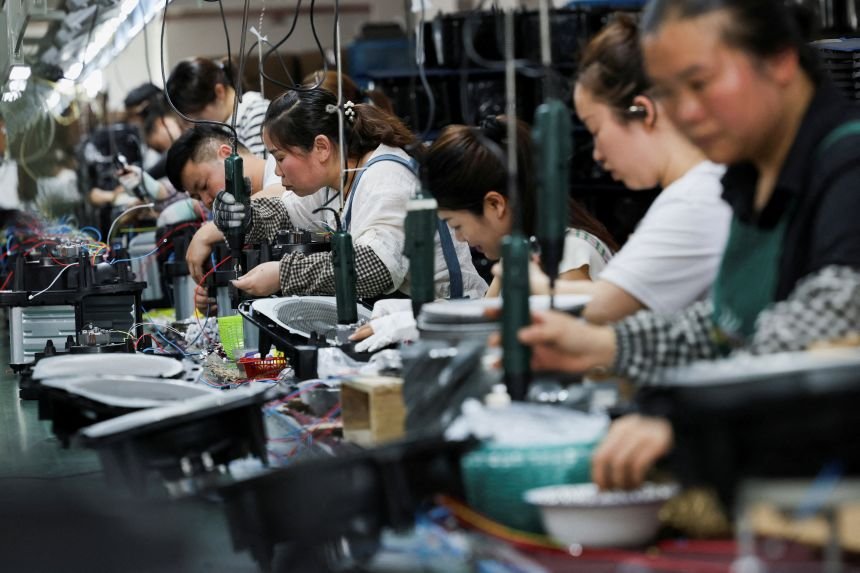 Employees work to assemble air fryers at a factory in Ningbo, China earlier this year.