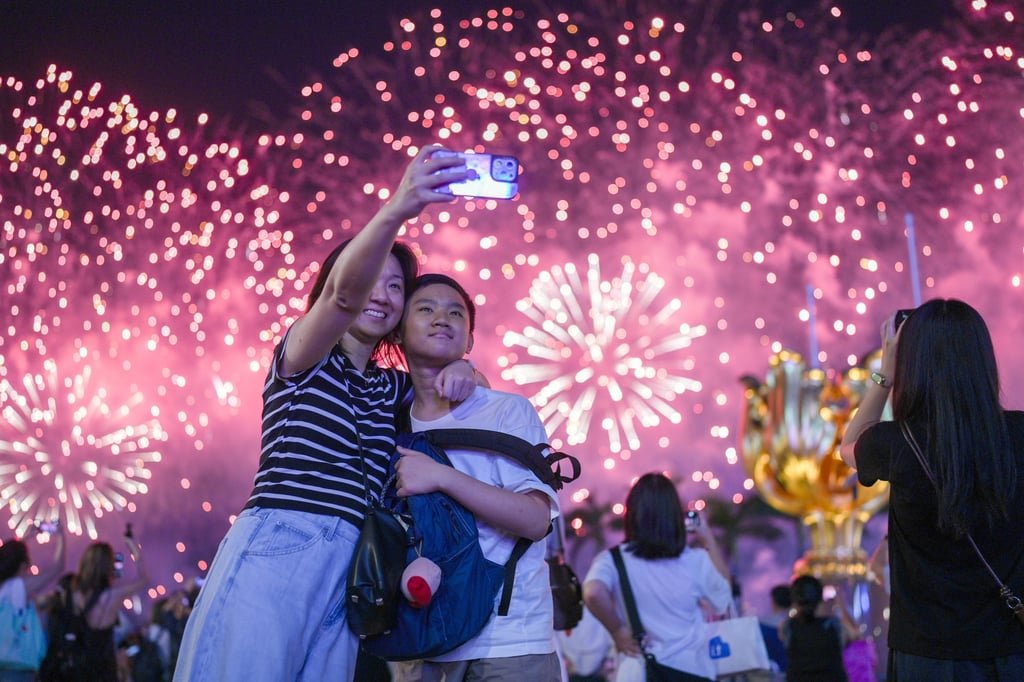 Revellers pose for a selfie during the fireworks display on National Day. Photo: Eugene Lee