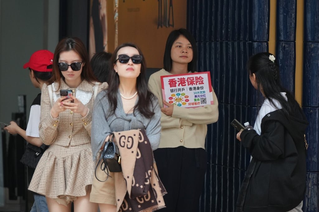 Insurance sales agents approach mainland tourists in Canton Road, Tsim Sha Tsui. Photo: Eugene Lee