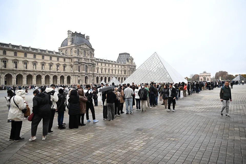 People queue outside the Louvre in Paris on Monday.