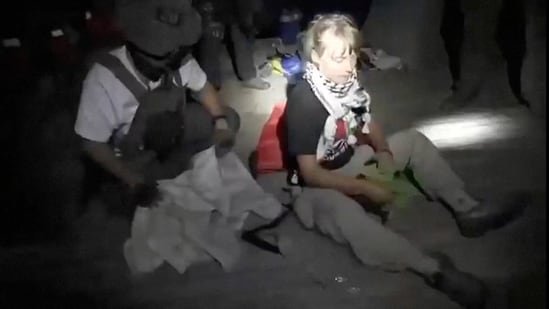 A screengrab from a video shows Swedish activist Greta Thunberg sitting next to a person wearing tactical gear, as vessels of the Global Sumud Flotilla are being intercepted by Israeli security forces, October 1, 2025. (via REUTERS)