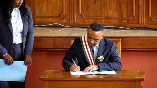 Madagascar's new military ruler, Colonel Michael Randrianirina, signs documents after being sworn in as president on Friday.(Reuters)