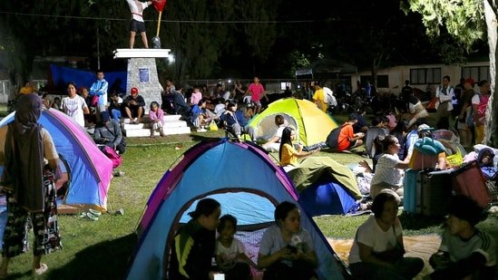 Residents gather at a park amidst a tsunami warning after a 6.7 aftershock hits Davao Oriental province, in Mindanao early evening on October 10, 2025.(AFP)