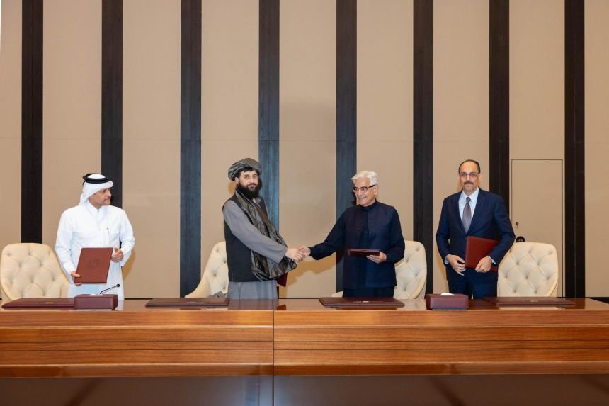 Afghan Defence Minister Mullah Muhammad Yaqoob, centre left, shakes hands with Pakistani Defence Minister Khawaja Muhammad Asif after reaching a ceasefire deal during talks in Doha, Qatar.