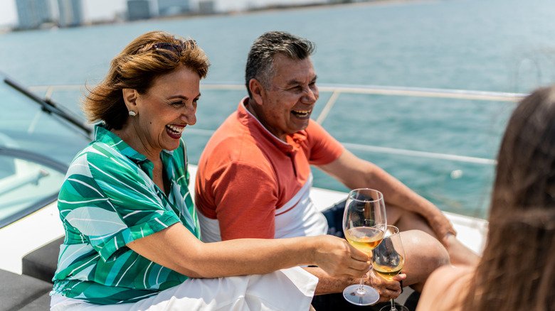 Smiling older wealthy couple drinking on a boat